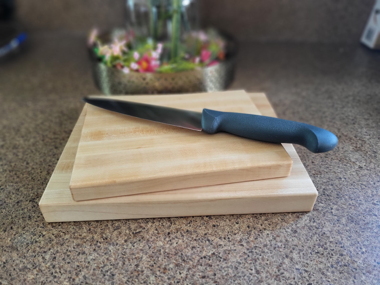 Two compact maple cutting boards with a cutting knife on top