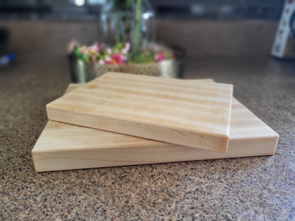 Two compact maple cutting boards with smooth surfaces, curved edges and a natural oil-and-wax finish
